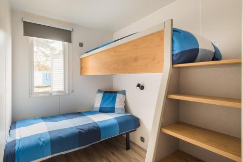 a small bedroom with a bunk bed and a window at Chalet O'hara in Bilthoven