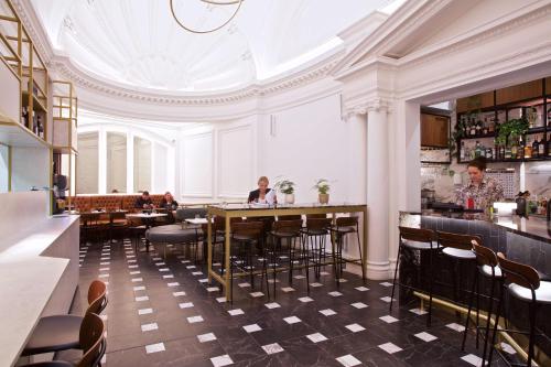 un restaurante con mesas y sillas y techo en The Z Hotel Holborn, en Londres