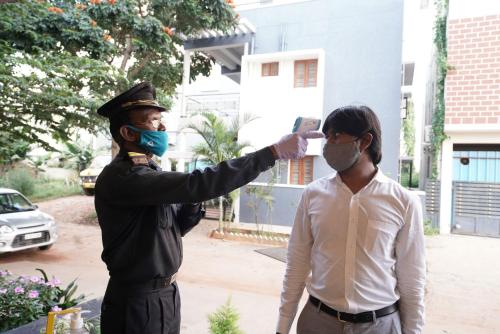 a man taking a picture of a man wearing a mask at Silicon Inn Hotel Bangalore Airport in Devanahalli-Bangalore