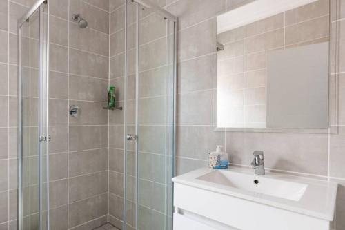 a bathroom with a shower and a sink and a mirror at Alimama Spaces: The Chelsea's Blyde in Pretoria