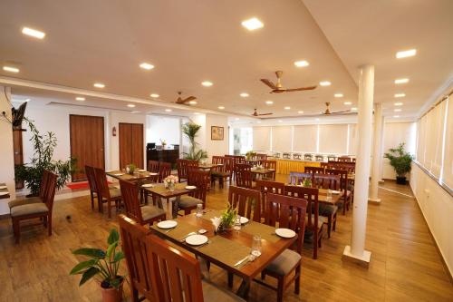 Devanhalli的住宿－Silicon Inn Hotel Bangalore Airport，用餐室配有木桌和椅子
