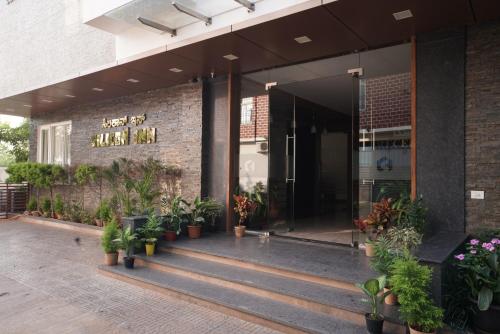 a building with potted plants in front of it at Silicon Inn Hotel Bangalore Airport in Devanahalli-Bangalore