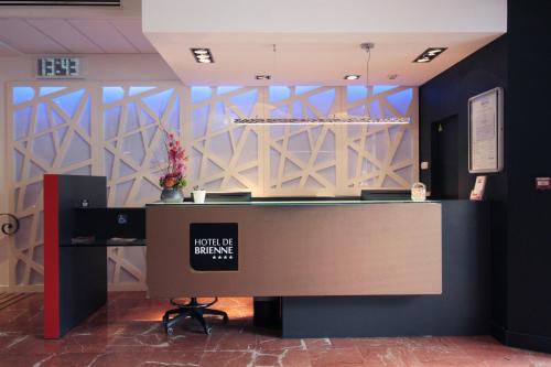 a reception desk in a room with a wall at Hôtel de Brienne in Toulouse