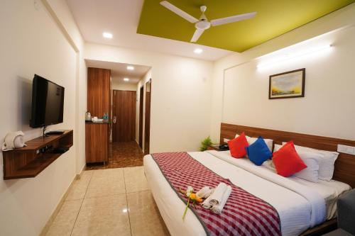 a hotel room with a bed and a flat screen tv at Silicon Inn Hotel Bangalore Airport in Devanahalli-Bangalore