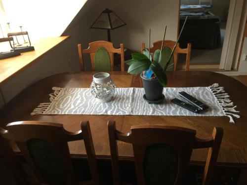 a dining room table with a table cloth and a plant on it at Sanddala Bed & Breakfast in Everöd