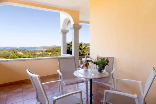 a dining room with a table and chairs and a large window at Villa Anastasia in Cugnana
