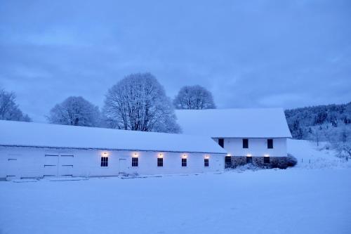 a white barn covered in snow at night at Boen Gård in Kristiansand