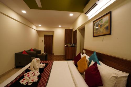 a hotel room with a bed with colorful pillows at Silicon Inn Hotel Bangalore Airport in Devanahalli-Bangalore