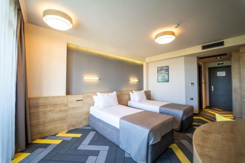 a hotel room with two beds and a projector screen at HVD Club Bor Ultra All Inclusive - Private Beach & Free parking in Sunny Beach