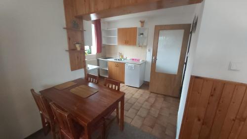 a small kitchen with a wooden table and a dining room at Apartmany U Ády in Železná Ruda