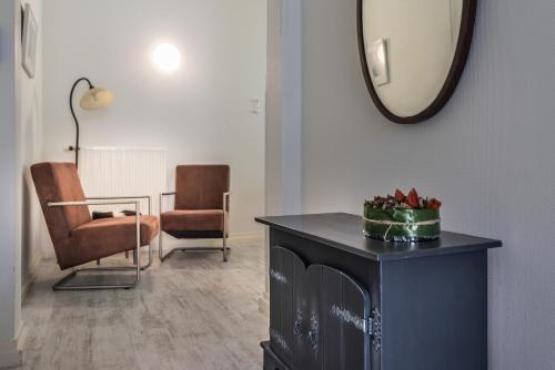 a living room with a mirror and a table and chairs at Boutique Appartement-Hotel Villa Juttershof in Bergen