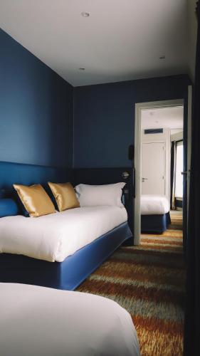 a bedroom with two beds and a blue wall at Trianon Gare de Lyon in Paris