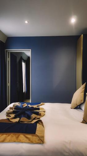 a bedroom with a large bed with a blue wall at Trianon Gare de Lyon in Paris