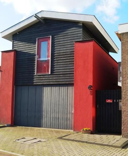 een zwart en rood huis met een raam bij B&B 16C Maassluis NL in Maassluis