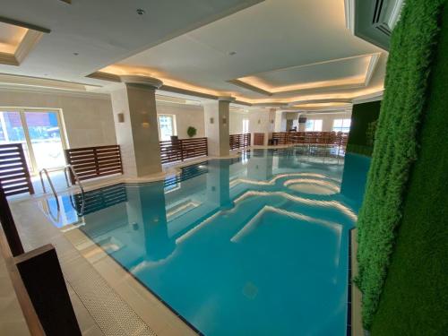 a large indoor swimming pool in a building at Magnum Hotel & Suites West Bay in Doha