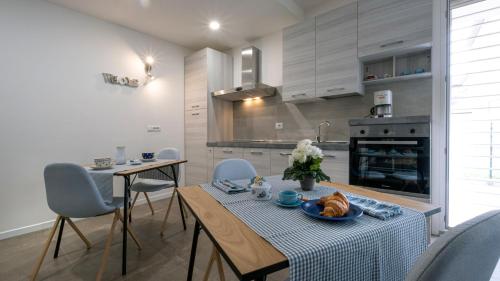 Maisonette Modena Park في مودينا: مطبخ مع طاولة وكراسي في غرفة