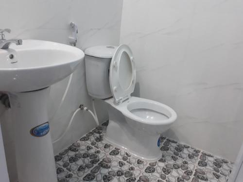 Łazienka z białą toaletą i umywalką w obiekcie Công ty TNHH Khách sạn Lê Phan w mieście Cu Chi