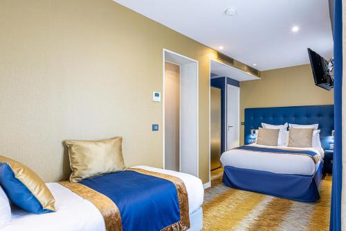 a hotel room with two beds and a tv at Trianon Gare de Lyon in Paris