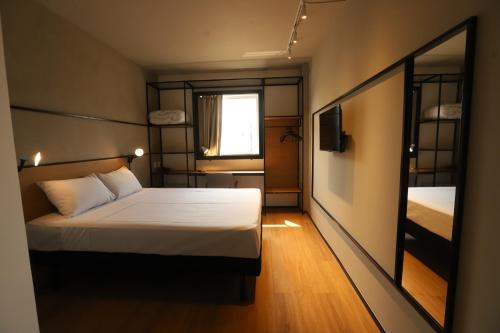 um pequeno quarto com uma cama e uma janela em ibis Cuiaba Shopping em Cuiabá