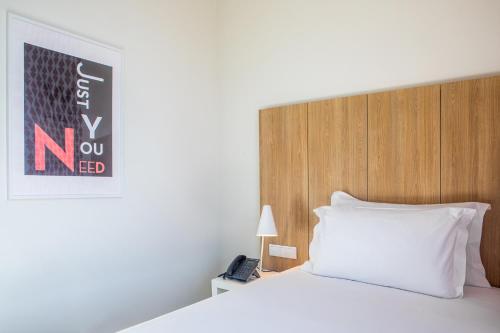 a bedroom with a bed and a lamp at Stay Hotel Lisboa Aeroporto in Lisbon