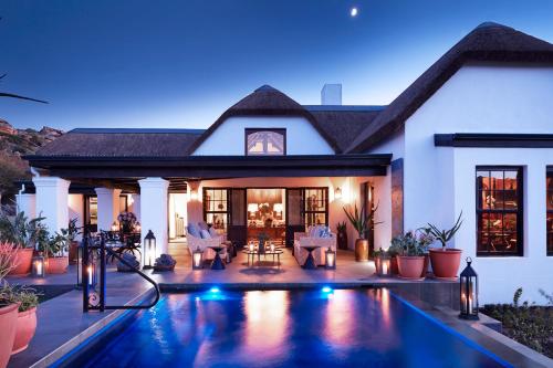 a house with a swimming pool in front of a house at Bushmans Kloof Wilderness Reserve and Wellness Retreat in Clanwilliam