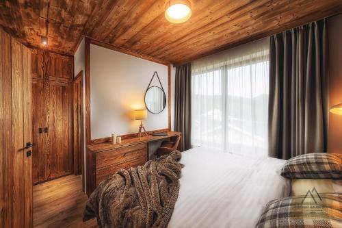 sypialnia z łóżkiem i drewnianym sufitem w obiekcie Apartment Claudie de Luxe w Demianowskiej Dolinie