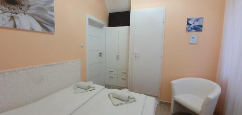 a bedroom with a white bed and a mirror at Anna vendégház in Szeged