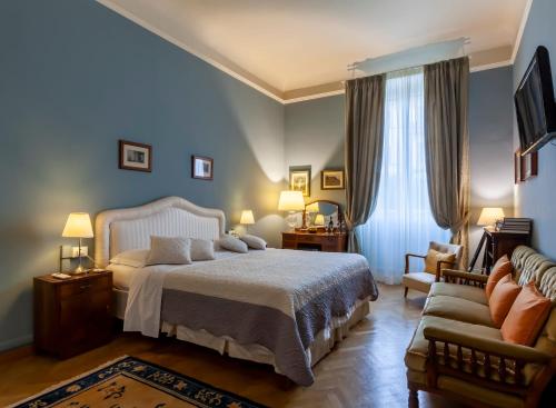 1 dormitorio con 1 cama y 1 sofá en Opera Boutique B&B, en Florencia
