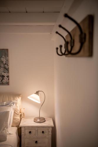 a lamp on a night stand next to a bed at Four Seasons Hydra Luxury Suites in Hydra
