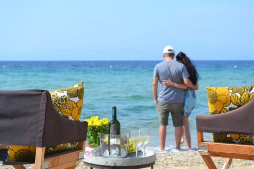 a couple standing on the beach with a bottle of wine at Exquisite Thassos Villa Villa Mare 4 Bedroom Private Pool Sea View Skala Prinos in Prinos