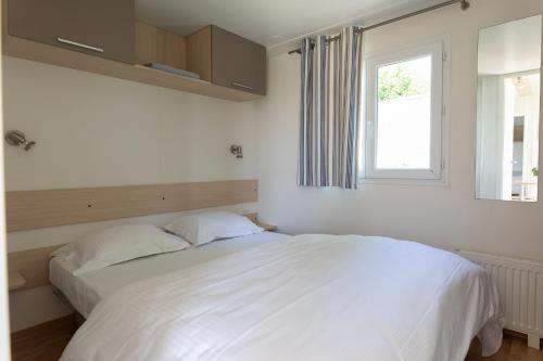a bedroom with two white beds and a window at Holidaypark Klein Strand in Jabbeke