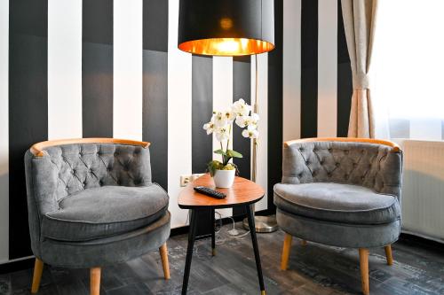 zwei Stühle und ein Tisch in einem Raum in der Unterkunft Highlight Apartment St Charles Church in Wien