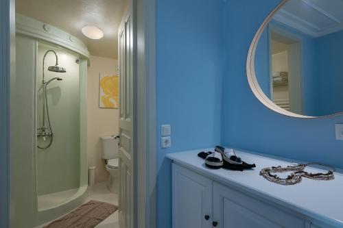 a blue bathroom with a sink and a mirror at Four Seasons Hydra Luxury Suites in Hydra