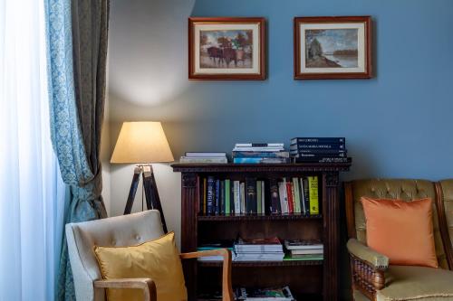 sala de estar con estante de libros y silla en Opera Boutique B&B, en Florencia