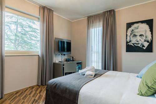 a hotel room with a bed and a window at L'aja della Mirusina - Piedmont Resort Monferrato Langhe in Canelli
