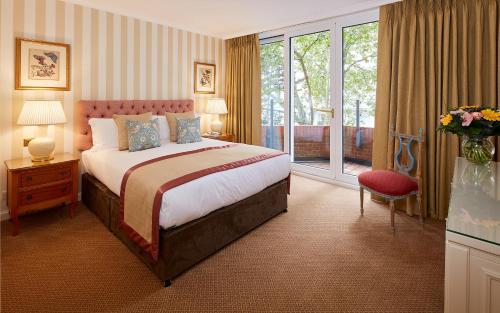 a hotel room with a bed and a window at Cheval Thorney Court at Hyde Park in London