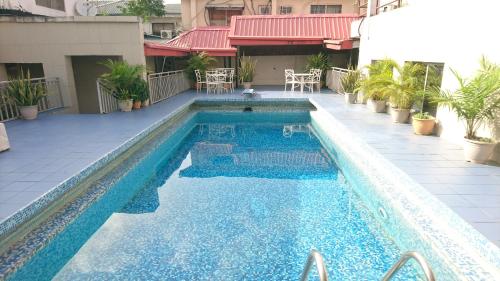 ラゴスにあるThe Ambassadors Hotelの建物内の青い水のスイミングプール