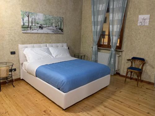 una camera da letto con un grande letto con una coperta blu di Appartamento liberty con area giochi a Udine