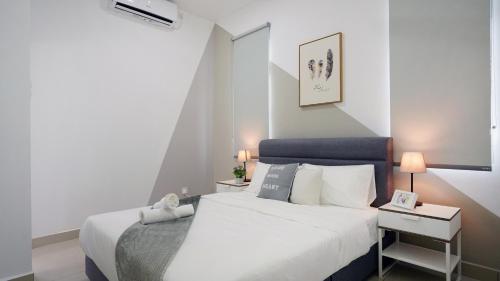 a bedroom with a white bed with a blue headboard at Desaru Minimalism Muji Style by Joyfully 35M7 in Desaru
