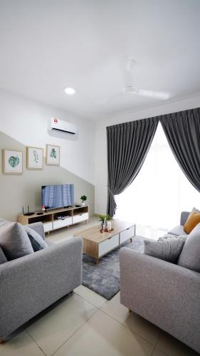 a living room with two couches and a tv at Desaru Minimalism Muji Style by Joyfully 35M7 in Desaru