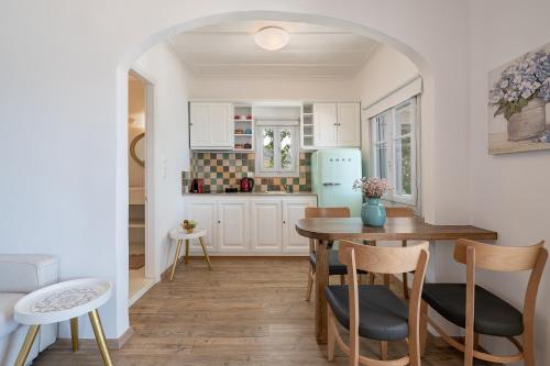 a kitchen with a table and chairs and a refrigerator at Four Seasons Hydra Luxury Suites in Hydra