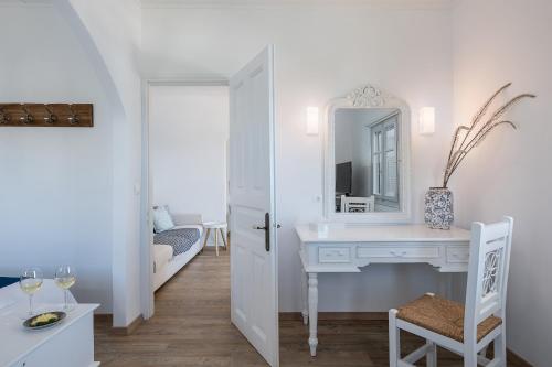een witte badkamer met een wastafel en een spiegel bij Four Seasons Hydra Luxury Suites in Hydra