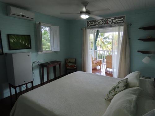 a bedroom with a bed and a window with a patio at Sand Dollar Beach Bed & Breakfast in Bocas del Toro