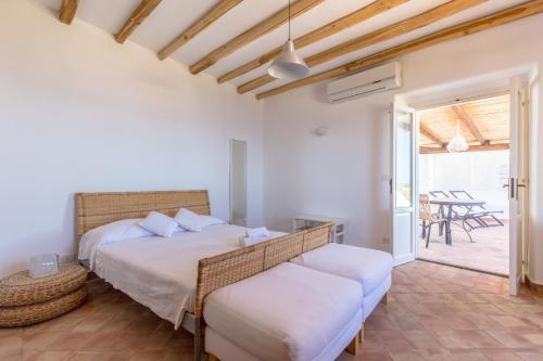 a bedroom with two beds and a patio at LE CASETTE DI MALFA in Malfa