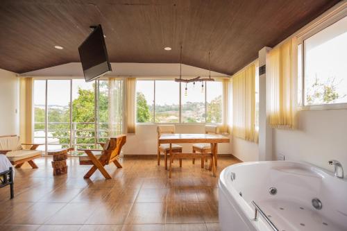 波帕扬Hotel Campestre La Posada Del Rancho的一间带浴缸和桌子的浴室以及一间用餐室