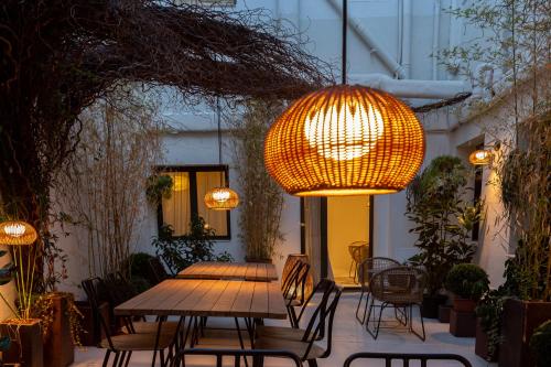 a patio with a wooden table and chairs and lights at Hotel Avenida in Zaragoza