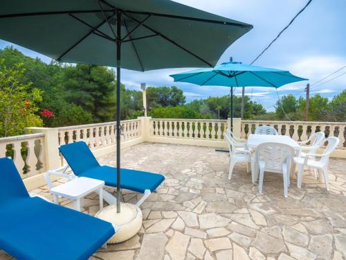 un patio con sillas, mesas y sombrillas en Holiday Home Can Toni Mari by Interhome, en Sant Carles de Peralta
