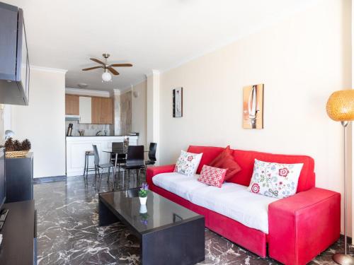 sala de estar con sofá rojo y mesa en Apartment Buenavista by Interhome, en Acantilado de los Gigantes