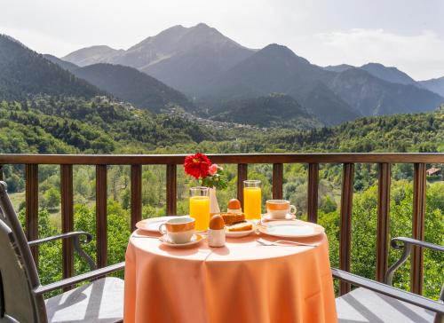 a table on a balcony with a view of mountains at Rizoma Guesthouse in Mikrón Khoríon