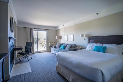 Un pat sau paturi într-o cameră la Manoir des Sables Hôtel & Golf
